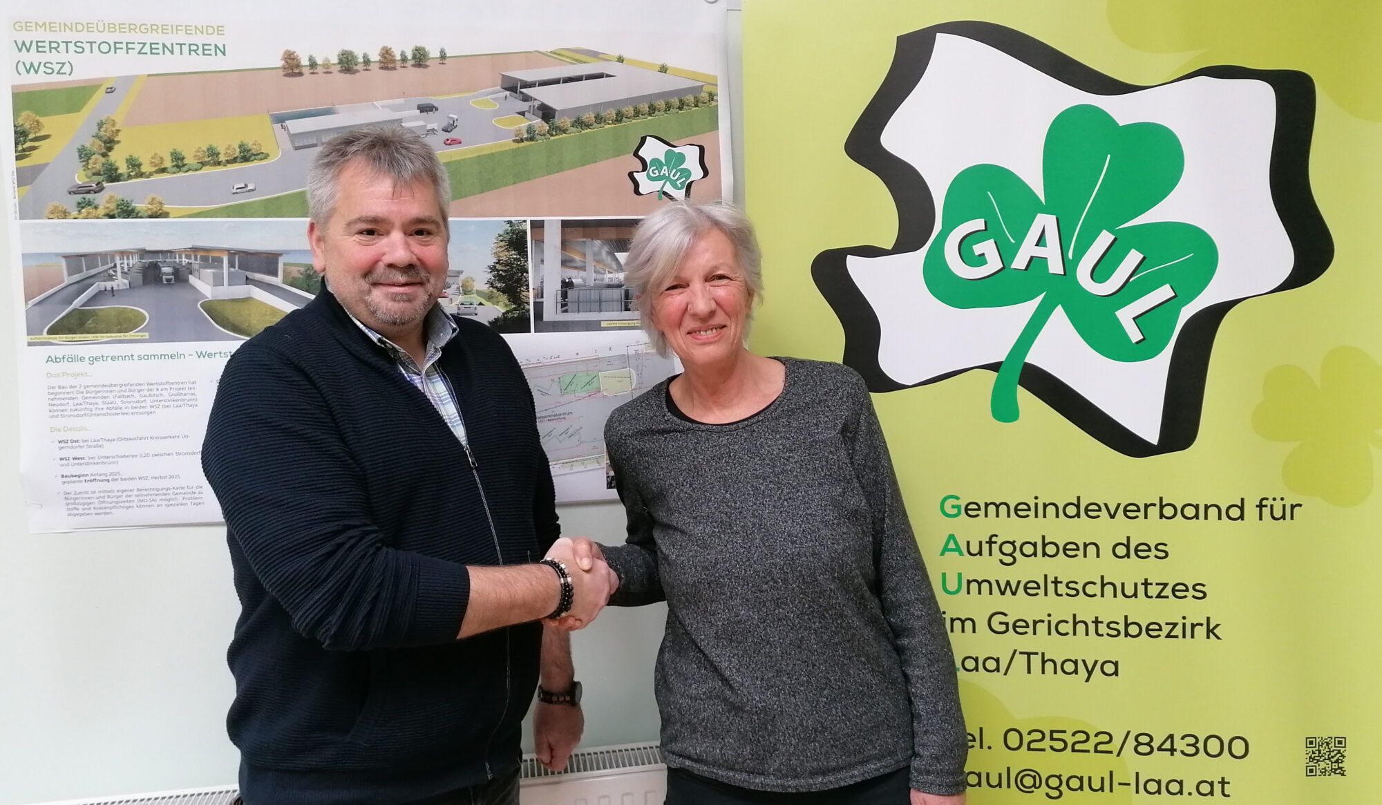 Der neue Obmann Bgm. Franz Popp dankt der ehemaligen Obfrau Bgm. Karin Gepperth. Im Hintergrund ist das GAUL Logo und Bilder vom neuen WSZ zu sehen.