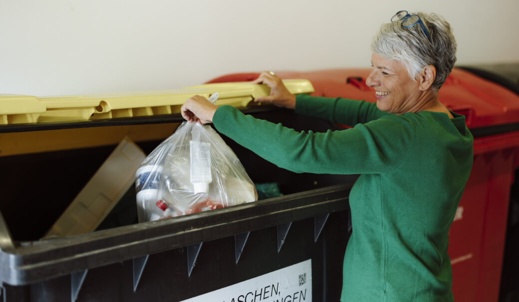 Gelber Sack Entsorgung von einer Dame im M&uuml;llraum.