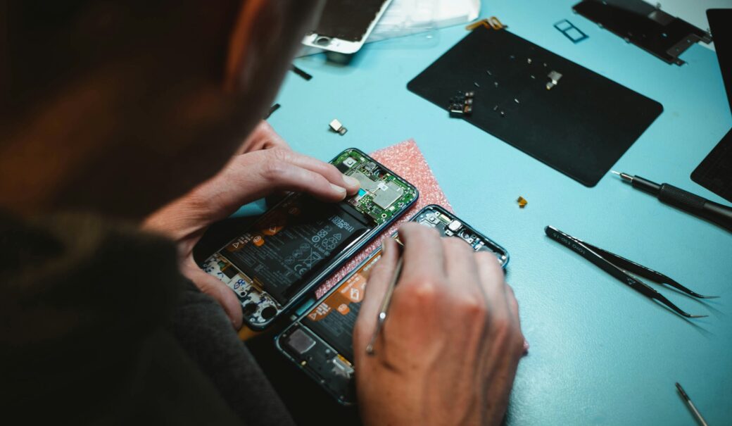 Ein Mann repariert ein Handy, das zerlegt wurde.