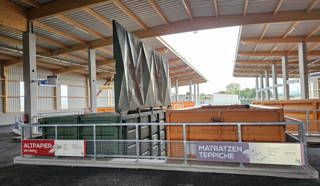 Ansicht auf die Container für die Sammlung von Altpapier und Matratzen/Teppichen